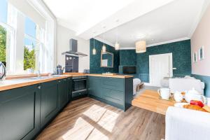 una cucina con armadi verdi e pavimenti in legno di Ashbrooke Apartment Keswick a Keswick
