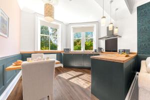 una cucina con bancone e tavolo con sedie di Ashbrooke Apartment Keswick a Keswick
