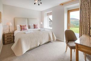 Un dormitorio blanco con una cama grande y una ventana en Granary en Melrose