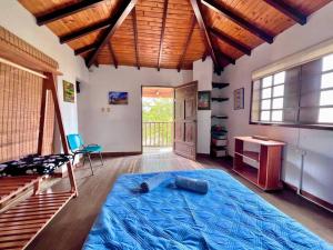 una camera da letto con un grande letto blu in una stanza di Hermosa Casa de Campo los Montes en Zapatoca a Zapatoca
