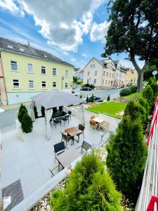 a patio with a table and chairs and a umbrella at Pension Goldenes Vogtland in Adorf