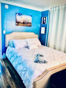 ein blaues Schlafzimmer mit einem Bett mit einem Hund drauf in der Unterkunft Beautiful Oceanview Retreat 2 Bedroom Home in Port Hadlock