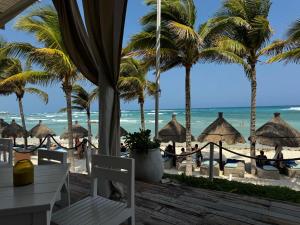 a view of the beach from a resort with palm trees at Golf & Beach Haven in Tulum