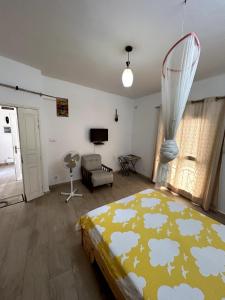 a bedroom with a bed with a yellow blanket with clouds at Chambre avec balcon - salle de bain extérieure privée & breakfast in Saint-Louis