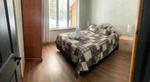 a bedroom with a bed with a plaid blanket and a window at chalet le Taz in Saint Come