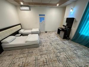 um quarto com 2 camas e uma televisão de ecrã plano em Athena Stars Hotel em Erbil