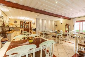 a dining room with white tables and chairs at Pousada D'Biagy Raízes in Campos do Jordão