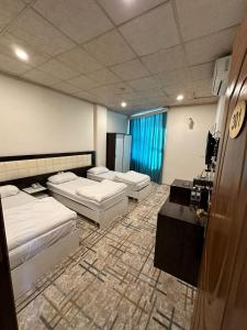 um quarto com duas camas e uma televisão em Athena Stars Hotel em Erbil