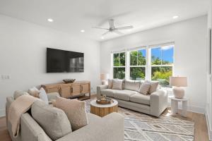a living room with two couches and a flat screen tv at Pearl House at The Gemma by Brightwild in Clearwater Beach