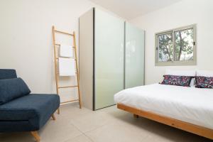 een slaapkamer met een bed en een stoel bij Luxury Dolphin House in Tel Aviv