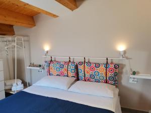 a bedroom with a bed with colorful pillows at CasAnna in Castellammare del Golfo