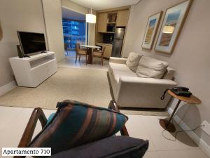 a living room with a couch and a tv at Book Santos - Estanconfor 710 e Estanconfor 810 Apto Executivo in Santos