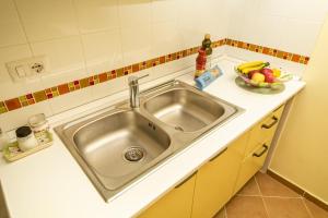 a kitchen sink with a bowl of fruit on the counter at Confortevole appartamento per due con servizi inclusi in Agropoli +12 photos