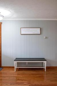 ławka w pokoju z białą ścianą w obiekcie Tranquility Cottage 