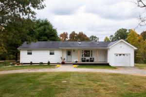 a white house with a garage at Tranquility Cottage 