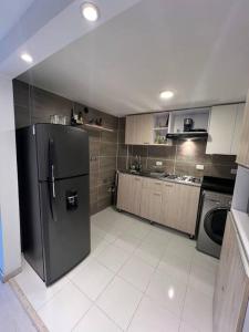 una cucina con frigorifero in acciaio inossidabile di Apartamento - Luz House a Bogotá