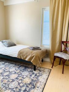 a bedroom with a bed and a window and a chair at KokkolaDream - Historical Timber Home in Kokkola