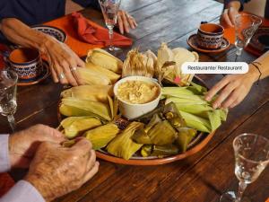 a group of people sitting at a table with a plate of food at Cabin Manzana Nature Retreat with amenities in Zitácuaro