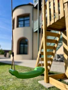 a green swing in front of a house at Residence Barrique Valtice in Valtice