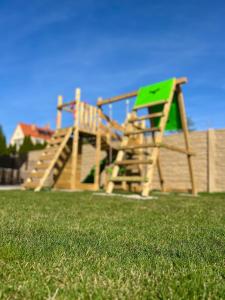 un parque infantil con un tobogán en un campo de césped en Residence Barrique Valtice, en Valtice