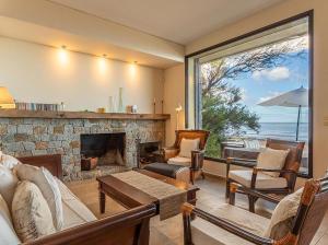 a living room with a fireplace and a view of the ocean at Casa espectacular directo sobre el mar in Las Flores