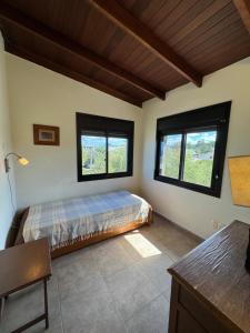 a bedroom with a bed and two windows at Casa espectacular directo sobre el mar in Las Flores