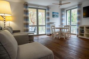 ユラタにあるSurf&biKe apartments Jurataのソファとテーブルと椅子のあるリビングルーム