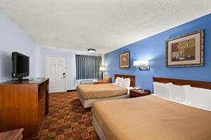 a hotel room with two beds and a flat screen tv at Americas Best Value Inn-Celina in Celina