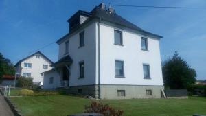ein großes weißes Gebäude mit schwarzem Dach in der Unterkunft Gästezimmer M. Schubert in Oberelbert