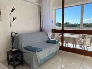 sypialnia z łóżkiem i balkonem z widokiem na okolicę w obiekcie T1 rénové avec balcon, clim, wifi, à Balaruc-les-Bains - FR-1-553-220 w mieście Balaruc-les-Bains