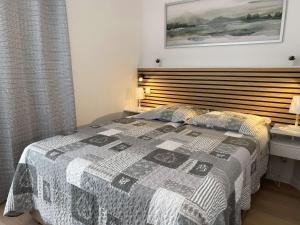 sypialnia z łóżkiem z drewnianym zagłówkiem w obiekcie T1 rénové avec balcon, clim, wifi, à Balaruc-les-Bains - FR-1-553-220 w mieście Balaruc-les-Bains