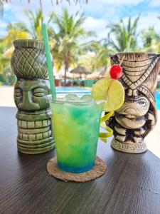 una bebida sentada en una mesa junto a dos jarrones en Paradise Resort, en Los Santos
