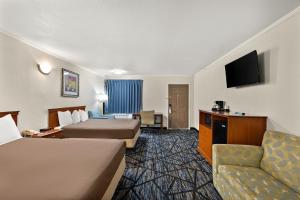 a hotel room with two beds and a flat screen tv at Americas Best Value Inn-Celina in Celina