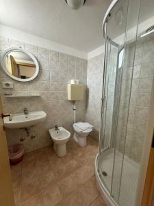 a bathroom with a toilet and a sink and a shower at Hotel Stradiot in Rimini