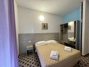 una camera da letto con un letto con due asciugamani sopra di Hotel Stradiot a Rimini