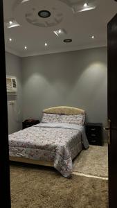 een slaapkamer met een bed met een deken erop bij استراحة وشاليه عزوز in Yanbu