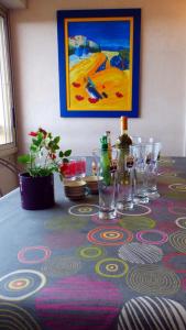 una mesa con copas de vino y una pintura en la pared en Spacious apartment a few steps from the sea, en Six-Fours-les-Plages