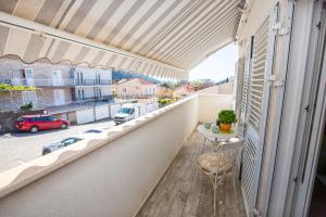 a balcony with a table and a view of a street at Apartment Happy Cat in Dubrovnik