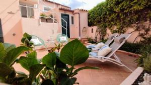 a patio with two chairs and a house at La Maisonette - Centro storico in La Maddalena