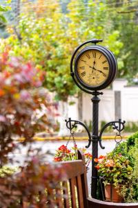 a clock on a pole next to a bench at Pousada Villa D'Biagy in Campos do Jordão