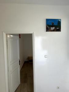 an empty room with a door and a picture on the wall at Chambre tout confort avec salle de bain intérieure privée - Clim & breakfast in Saint-Louis