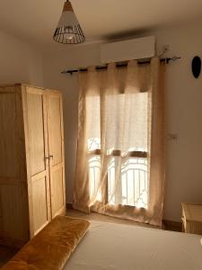 1 dormitorio con cama y ventana en Chambre tout confort avec salle de bain intérieure privée - Clim & breakfast, en Saint-Louis