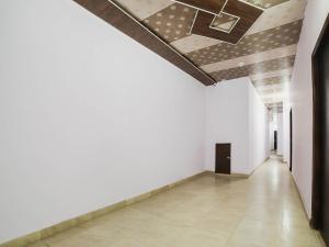 un couloir vide avec un mur blanc et un plafond dans l'établissement OYO Kl Khari Inn, à New Delhi