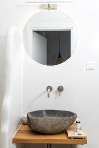 y baño con lavabo de piedra y espejo. en Alsea Seafront Apartments in Agia Pelagia Kythera, en Agia Pelagia - Citera