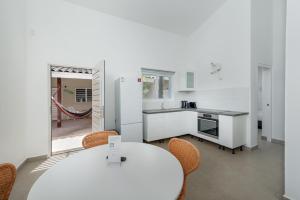 - une cuisine blanche avec une table et des chaises blanches dans l'établissement Casita Palma, à Kralendijk