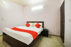 - une chambre avec un grand lit et des oreillers rouges dans l'établissement OYO Kl Khari Inn, à New Delhi