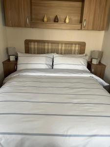 een groot wit bed in een slaapkamer met 2 lampen bij Miss Pollys Hideaway in Port Seton