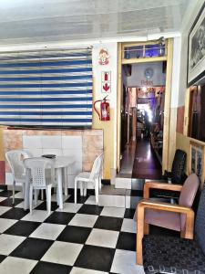 un ristorante con pavimento a scacchi e tavolo e sedie di Valleycenter guesthouse a Johannesburg
