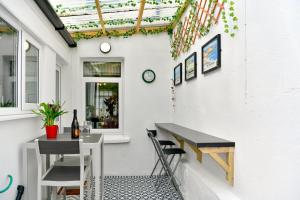 eine Terrasse mit einem Tisch und einer Flasche Wein in der Unterkunft Rare Free Parking in Heart of the City - Highly Rated Townhouse & Garden - Peaceful Area Less Than 5min Walk to Beach, Shops, Bars, Arena, Marina, Parks in Swansea + 38 Fotos