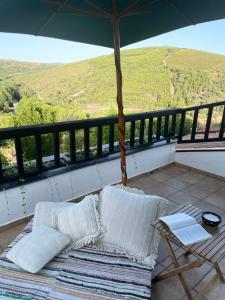 een balkon met een bed en een tafel en uitzicht bij Sweet Quintanilha 